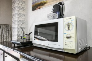 Compact kitchen area with a microwave and coffee maker, perfect for quick meals and coffee preparation.