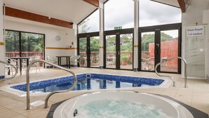 A pool area with a hot tub, outdoor seating, and a sign indicating a pool depth of 1.4 meters. - Manuka (Falmouth)
