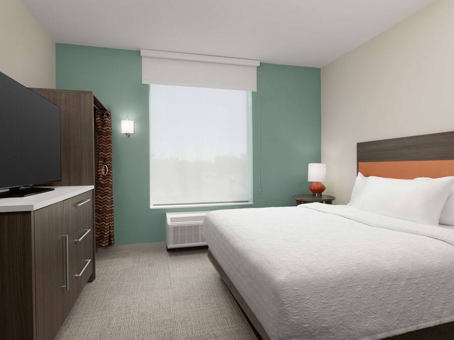 Habitación de hotel con cama, televisión, calefacción y ventana con vistas.