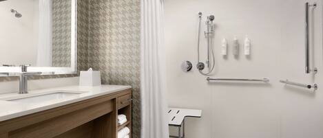 A modern bathroom with a shower, a sink, and a mirror.