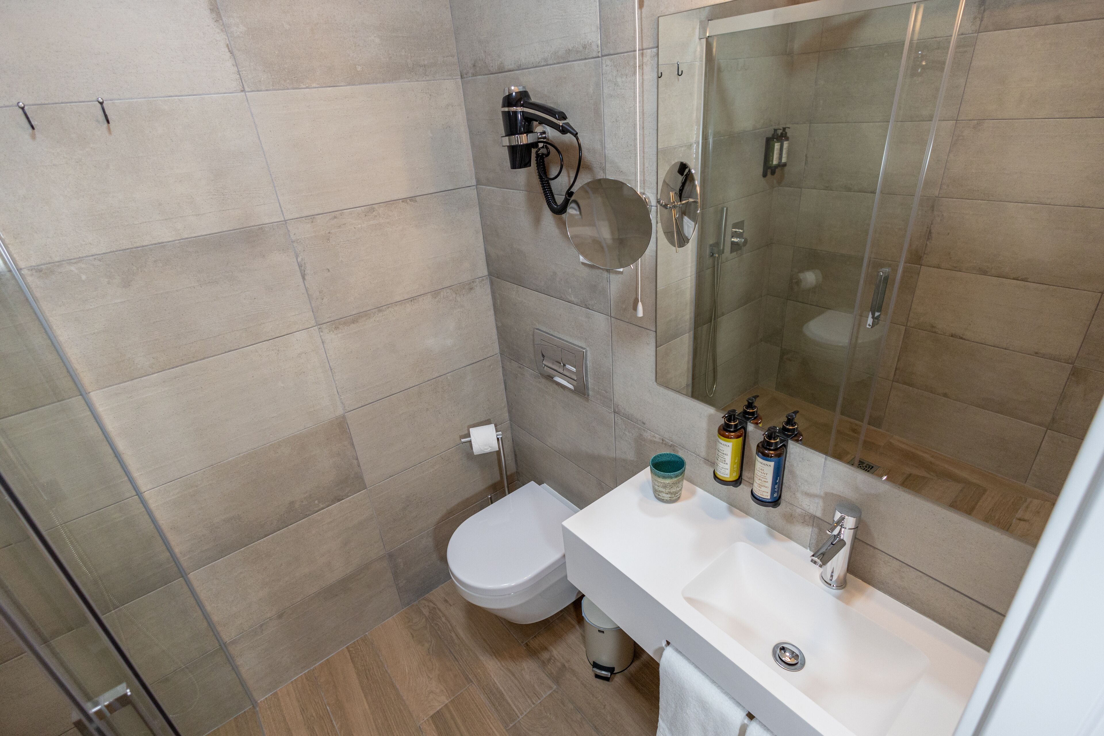 A bathroom with a toilet, sink, and shower.
