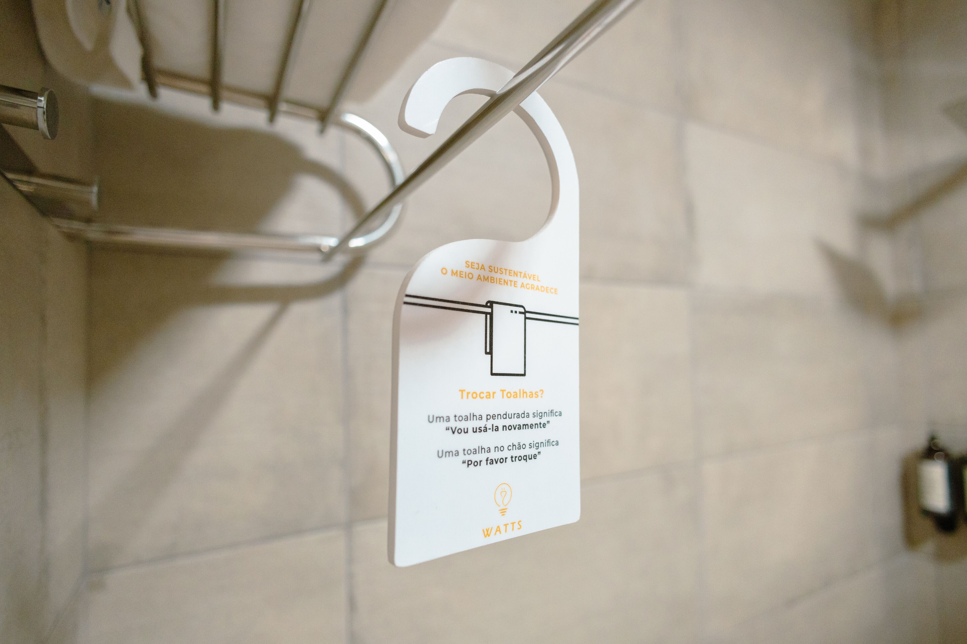 A sign with instructions for towel usage in a bathroom, advising to hang towels to save water.