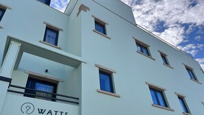 A modern building with a sign for 'Watts Entradas' indicating a hotel entrance. - Watts House (Seia)