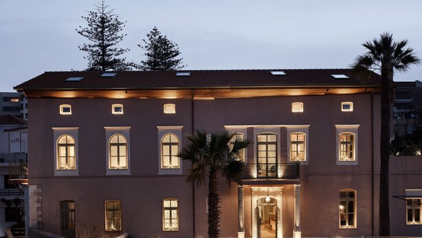 A large, two-story building with a symmetrical facade, multiple windows, and a central entrance with steps leading up to it. - Domus Blanc Boutique Hotel, Member of Domus Elegance Collection (Chania)