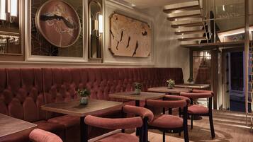 A restaurant with velvet booths, wooden tables, and modern decor.