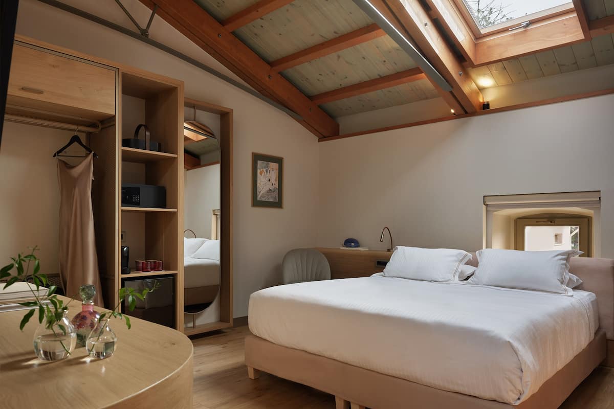 A bedroom with a bed, bedside table, and a wardrobe with a mirror.
