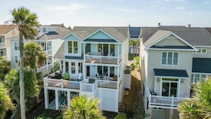A coastal residential area with multi-story houses featuring balconies, a dock, and a clear sky. - 332 Ocean Point (Fripp Island)