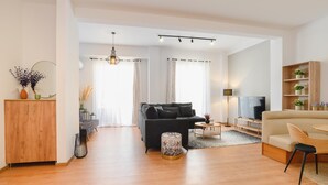 Una sala de estar moderna con un sofá, un televisor y un armario de madera.