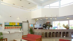 A reception area with a counter, seating, and a bulletin board. - Pola Costa Beach Hotel Apartment (Paralimni)
