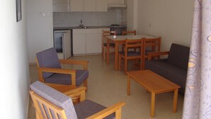 A compact living space with a kitchenette, a dining area, and seating. - Pola Costa Beach Hotel Apartment (Paralimni)