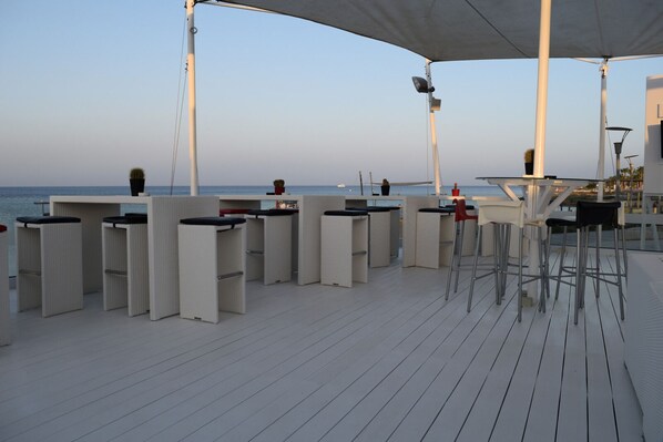 Une terrasse avec des sièges et une vue sur la mer.
