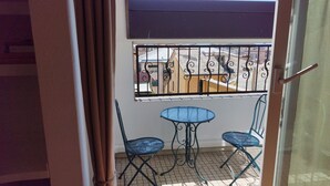 A balcony with a metal railing, a small table, and two chairs. - Cà DA MOÆ 1 - Very Central (Chiavari)