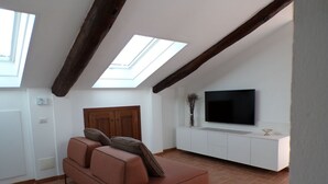 A modern living room with a sofa, a TV, and a skylight. - Cà DA MOÆ 1 - Very Central (Chiavari)