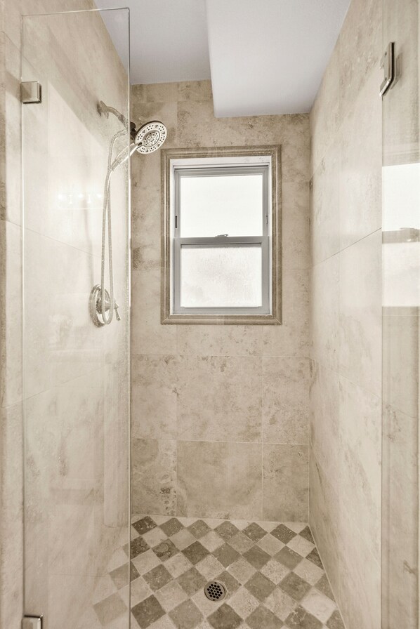 A shower with a glass door, a window, and a checkered floor pattern. - Pacific Beach Gem: Rooftop Deck, Bay Views, AC & Pet Friendly (San Diego)
