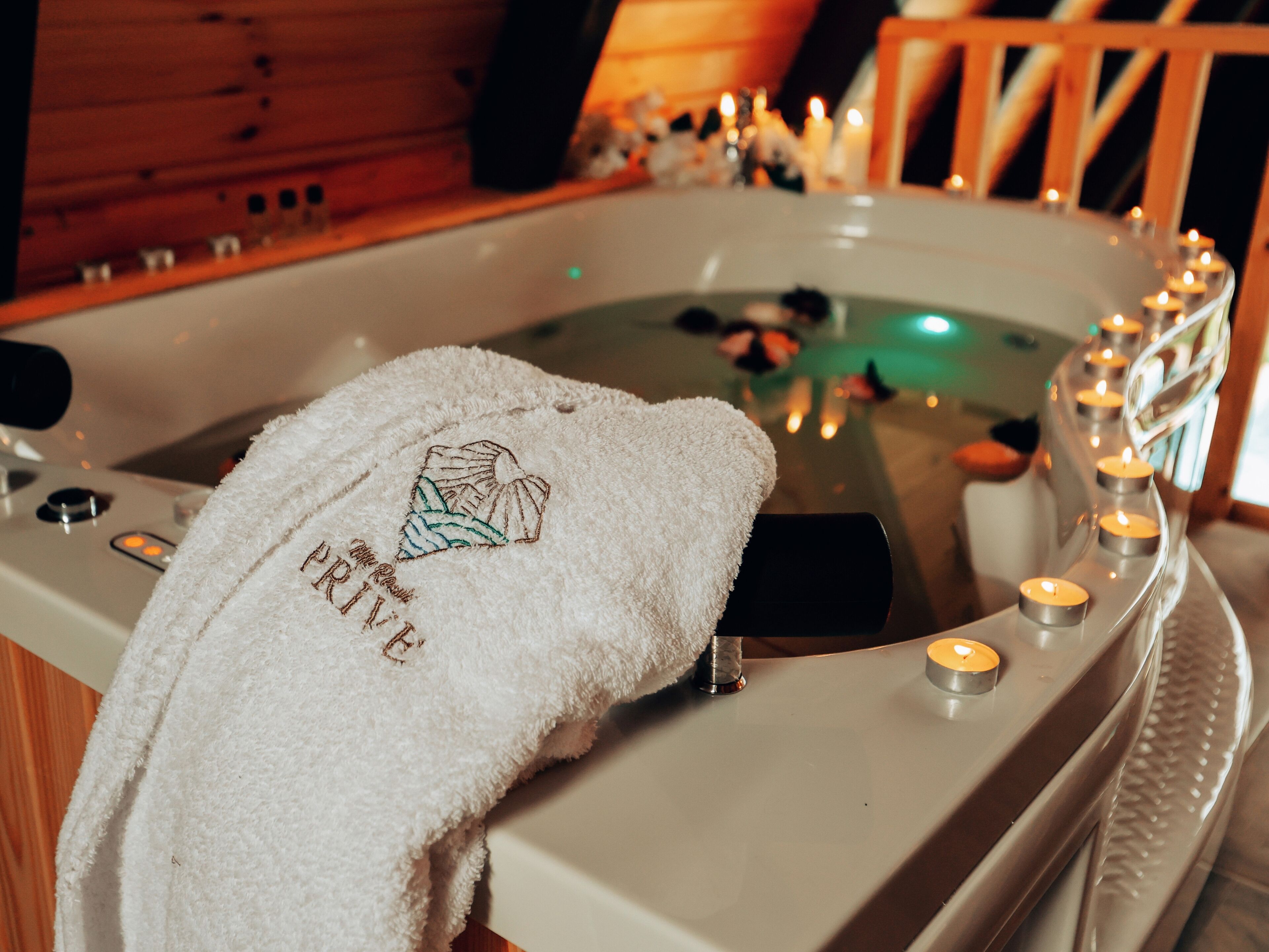 A hot tub with candles and a towel with a mountain design.
