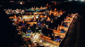 A nighttime view of a resort with multiple buildings, including a pool area and a covered deck. - MY RESORT PRİVE  (Sapanca)