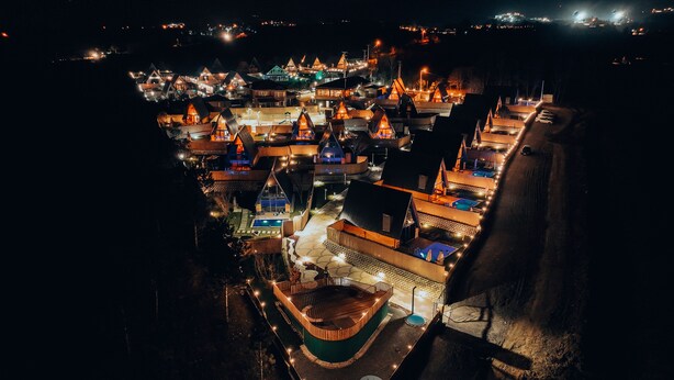 A nighttime aerial view of a resort with multiple buildings, a swimming pool, and a boat dock. - MY RESORT PRİVE  (Sapanca)