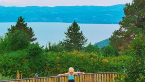 A wooden deck with a railing overlooking a lake and mountains. - MY RESORT PRİVE  (Sapanca)