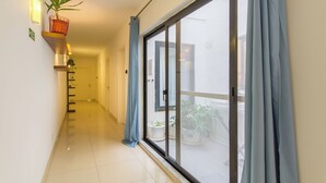 A hallway with a sliding glass door leading to a balcony with potted plants. - SwieqiStay room2 private bath - Paceville (Swieqi)