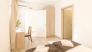 A hotel room with a bed, a desk, a chair, and a wardrobe. - SwieqiStay room2 private bath - Paceville (Swieqi)