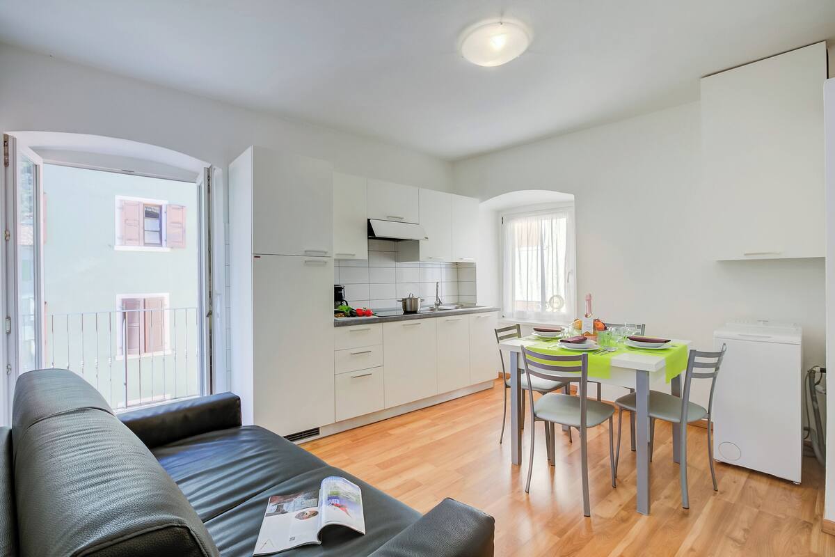 Un appartement moderne comprenant un espace de vie, une kitchenette et un coin repas.