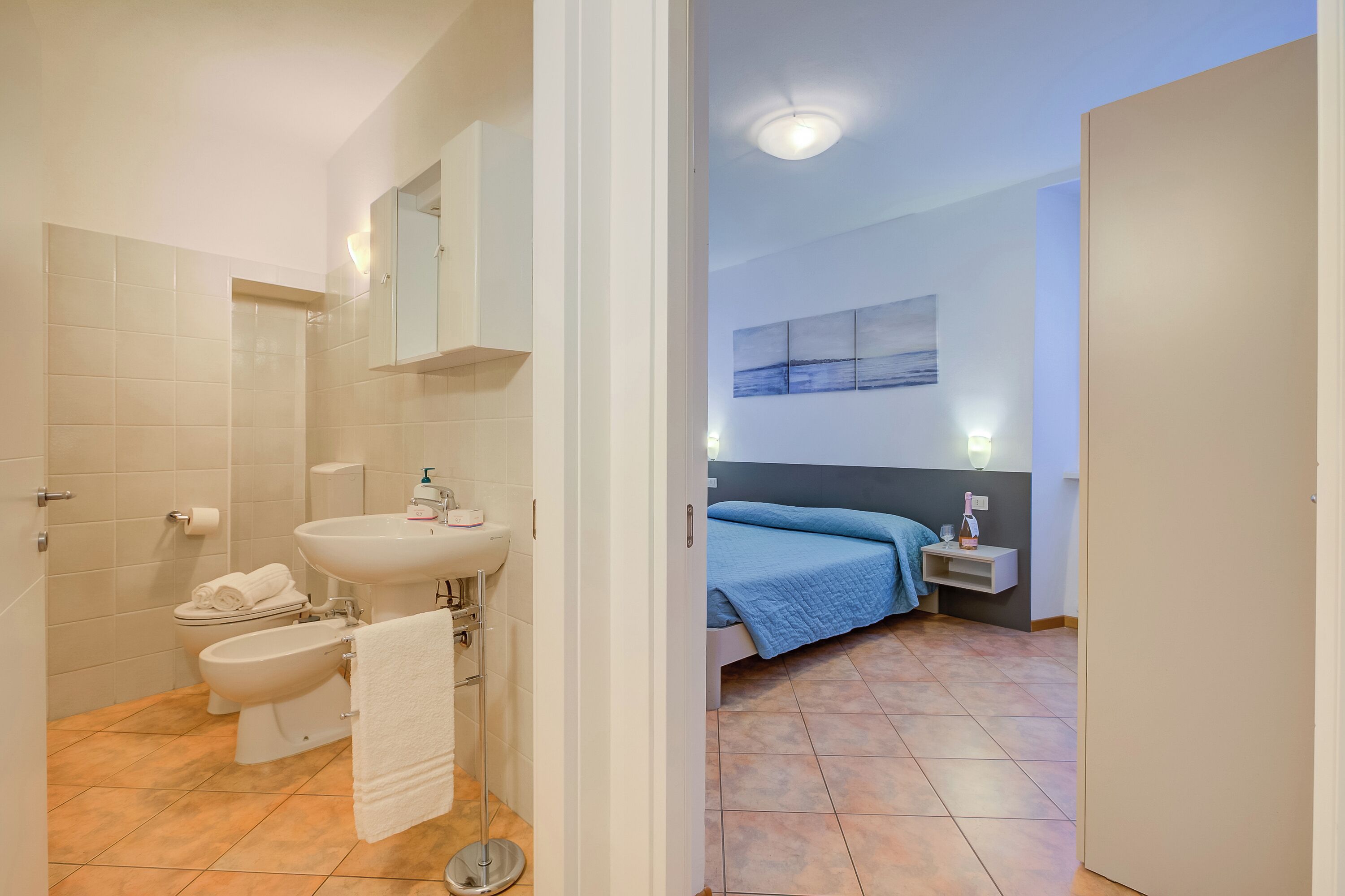 Une salle de bain équipée de toilettes, d’un bidet, d’un lavabo et d’un porte-serviettes.