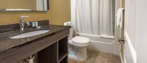 Une salle de bain avec un lavabo, des toilettes et une baignoire.