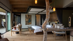 Un dormitorio moderno con una cama grande, muebles de madera y vistas al exterior.