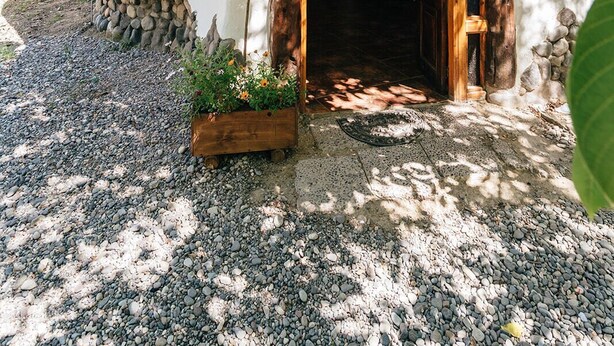 Una casa rústica de fusta amb fonaments de pedra, una porta de fusta i una finestra petita.