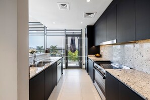 Premium appartement | Privékitchenette | Een koelkast met diepvriezer, een microgolfoven, een oven