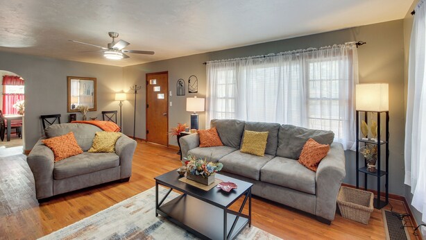 A living room with two grey sofas, a coffee table, a ceiling fan, and a floor lamp. - Missouri Escape w/ Furnished Patio, Near Downtown! (Nevada)