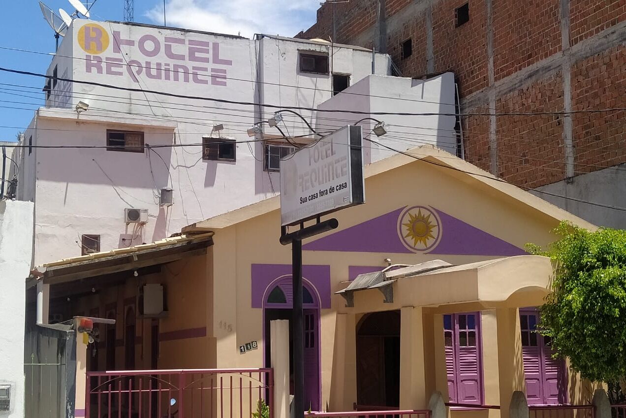 A hotel named "HOTEL REQUINCE" with a sign indicating "Sua casa laora de casa" and a sun symbol.