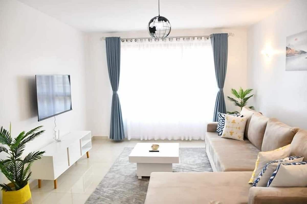 Una sala de estar moderna con un sofá, una mesita de centro y un televisor.