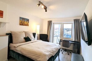 Relax in this spacious room with a large bed, desk, and chair, perfect for work or study.