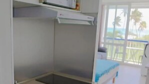 A compact kitchen with a sink, microwave, and a small refrigerator.