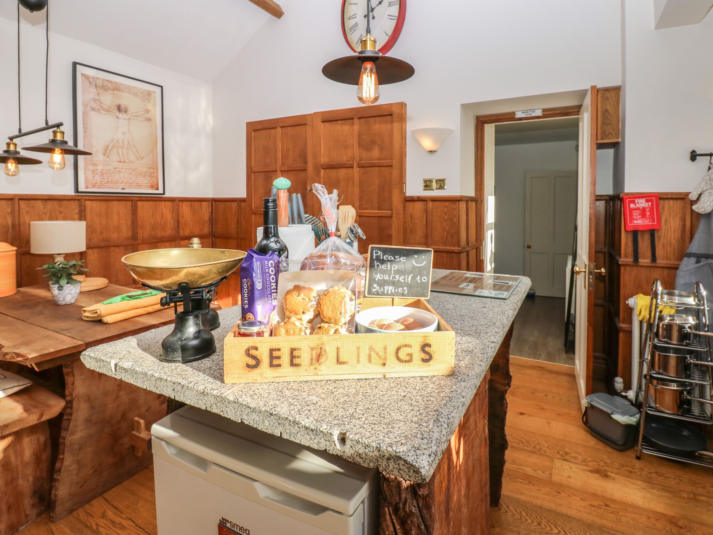 A kitchen counter with a sign reading "SEEINGS" and various food items.