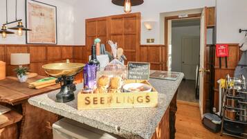 A kitchen counter with a sign reading "SEEINGS" and various food items.