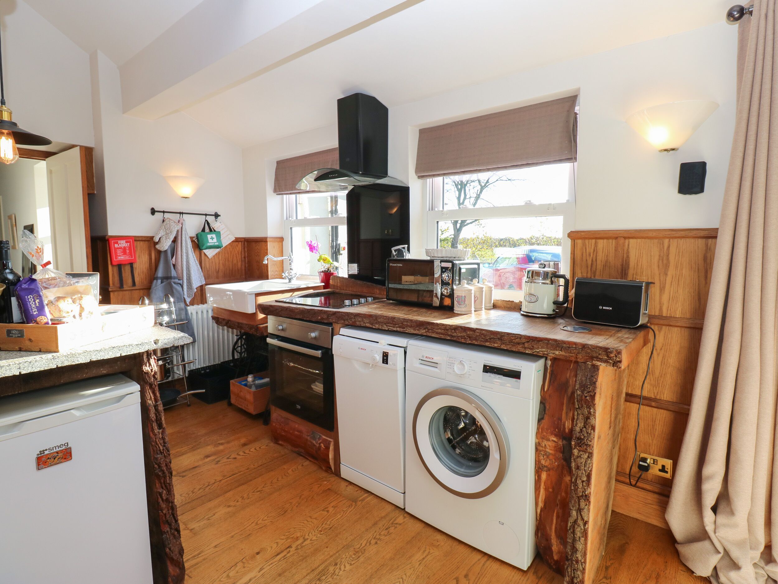A compact kitchen with a washing machine, toaster, and a coffee maker.
