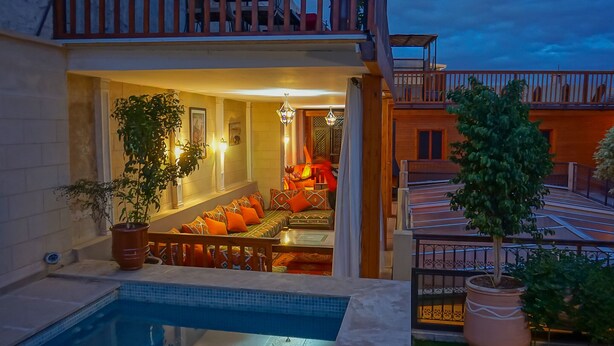 Un espace aménagé au bord de la piscine, comprenant un coin salon, une piscine et un balcon donnant sur la piscine.
