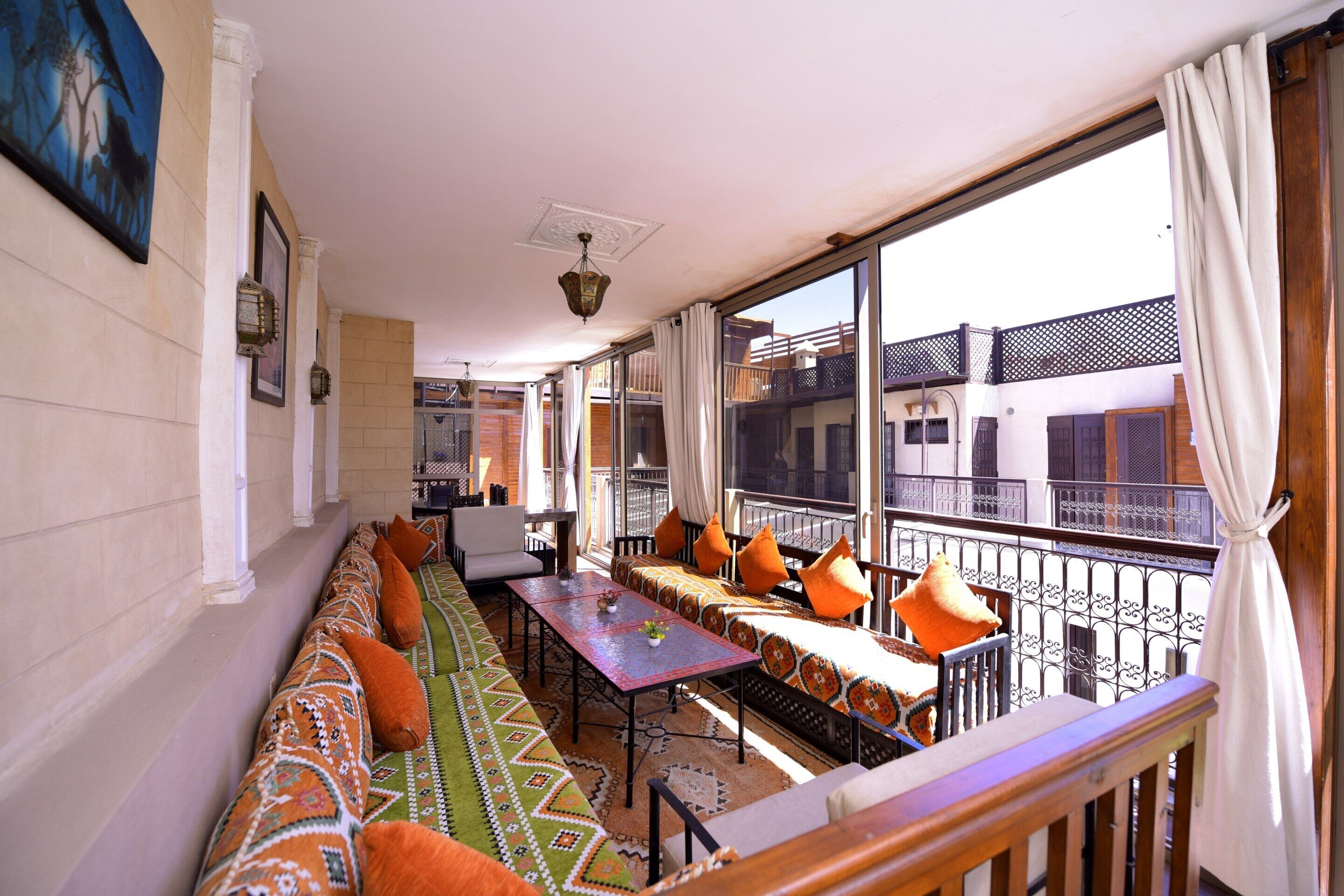Un balcón con sofá, mesa y sillas, con vista a un edificio.