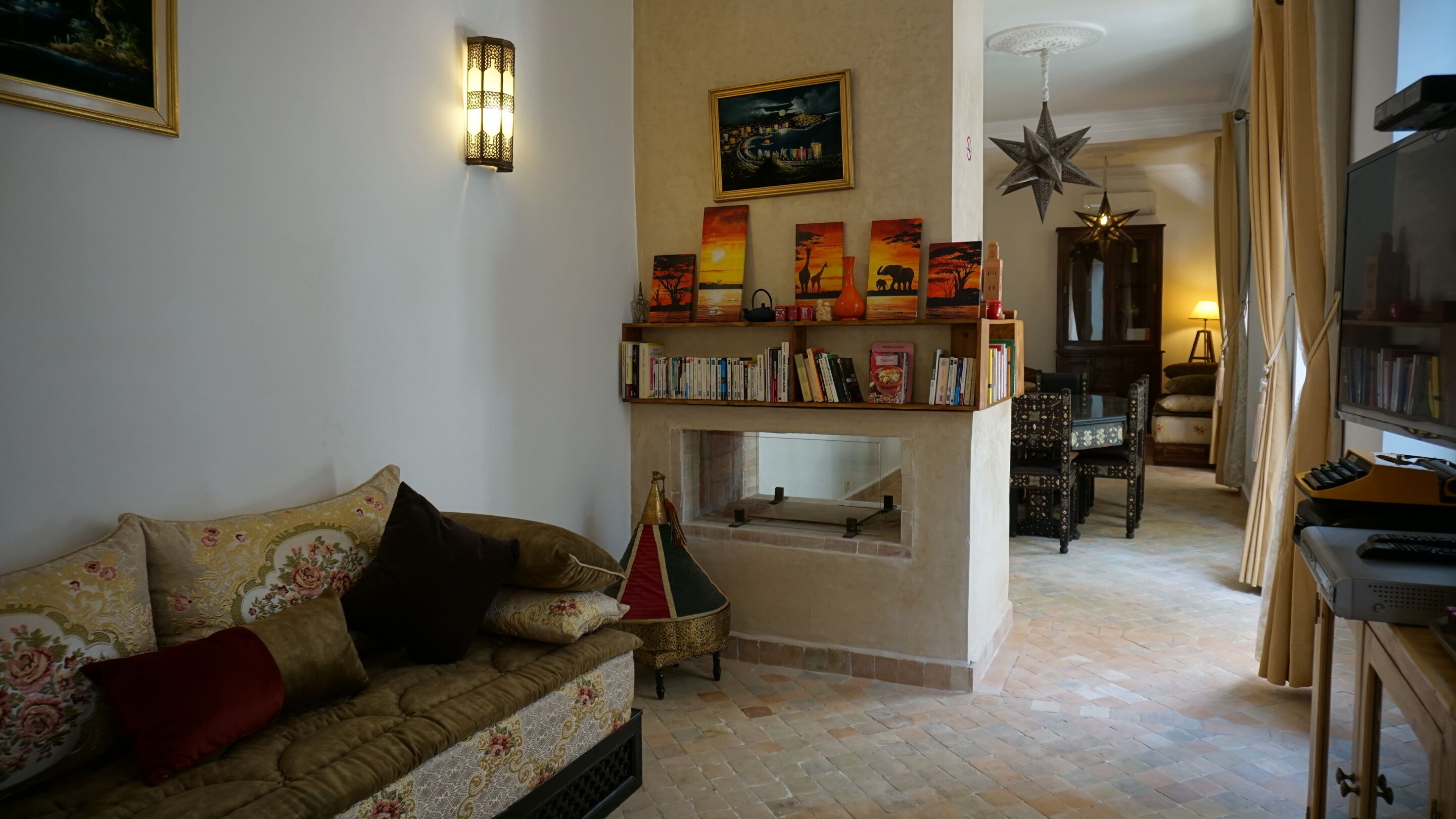 Un salon avec un canapé, une cheminée, une bibliothèque et un téléviseur.