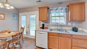 A kitchen with wooden cabinets, a dishwasher, a sink, and a window with a floral valance. - Georgetown Home ~ 6 Mi to Kentucky Horse Park! (Georgetown)