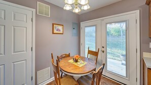 A dining area with a round wooden table, six chairs, a chandelier, and a door leading outside. - Georgetown Home ~ 6 Mi to Kentucky Horse Park! (Georgetown)