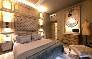 Classic design bedroom with a tufted headboard, wooden dresser, and bench.