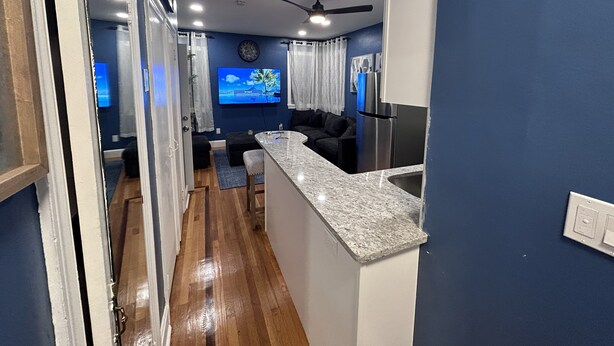 A modern kitchen with a granite countertop, stainless steel appliances, and a ceiling fan. - The Blue backyard studio suite!!  Convenience and practicality in one place!! (Allentown)
