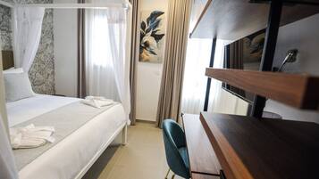 A hotel room with a bed, a desk, and a large window.