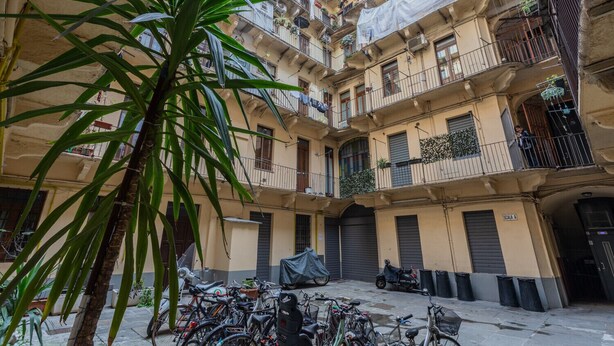 A multi-story residential building with balconies, a covered courtyard, and bicycles parked outside. - Special 10 apartment by Wonderful Italy (Torino)