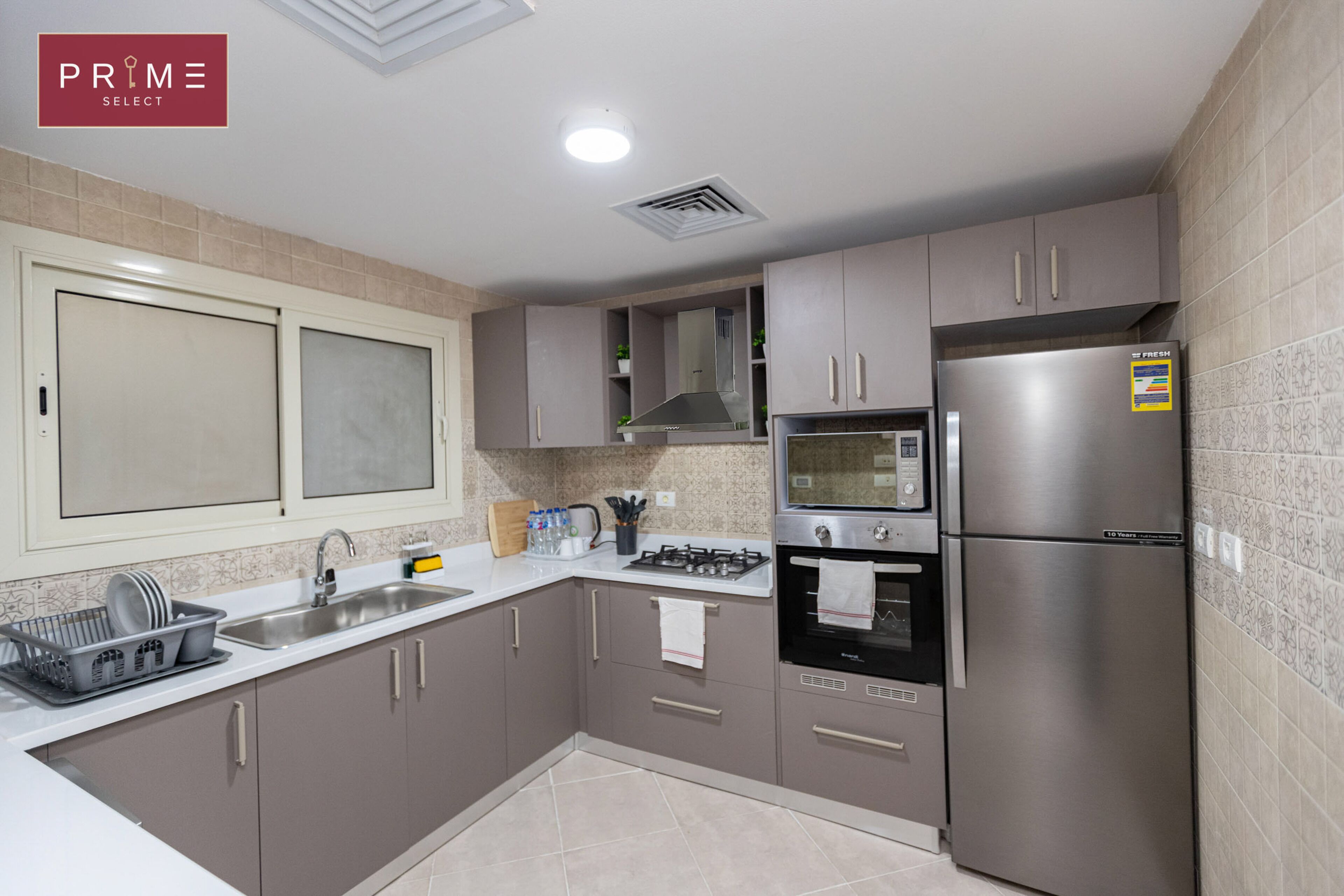 A modern kitchen with stainless steel appliances, a built-in oven, and a microwave.