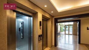 An elevator with a modern design, a control panel, and a glass door. - Prime Select New Giza (6th of October City)