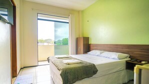 A hotel room with a bed, a nightstand, a wardrobe, and a view of the outside. - Hotel Pinheiro (Ibiapina)